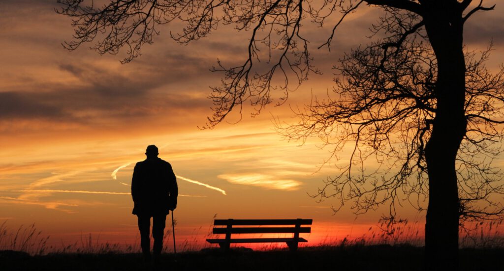 Ein alter Mann schaut dem Sonnenaufgang zu