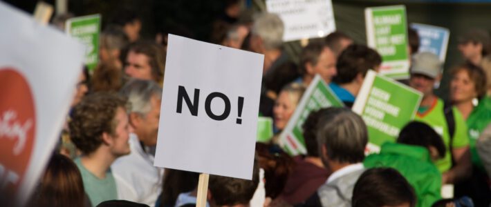 Menschen an einer Demonstration mit einem Schild «No»