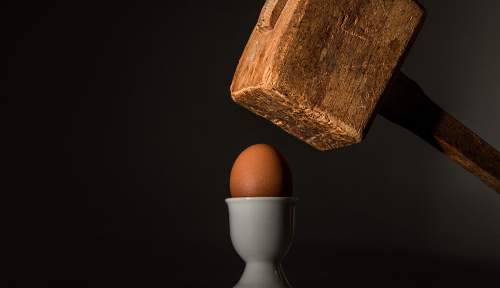 Ein Hammer fällt auf ein Ei