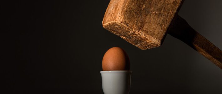 Ein Hammer fällt auf ein Ei