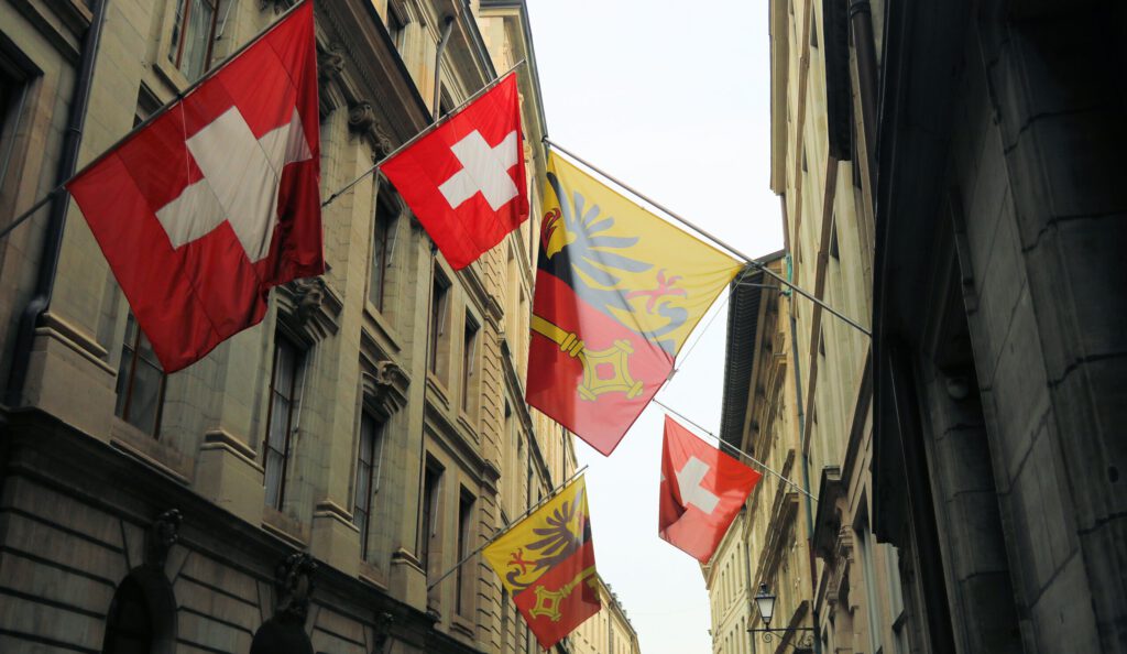 Schweizer Fahnen und Flaggen des Kantons Genf an einer Strasse