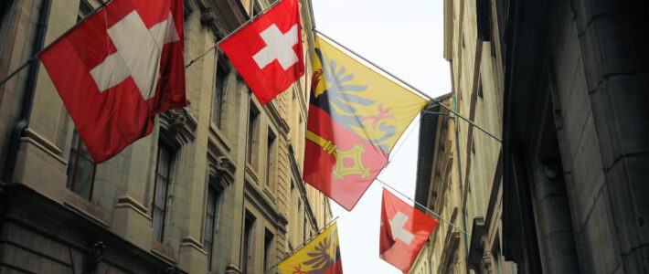 Schweizer Fahnen und Flaggen des Kantons Genf an einer Strasse