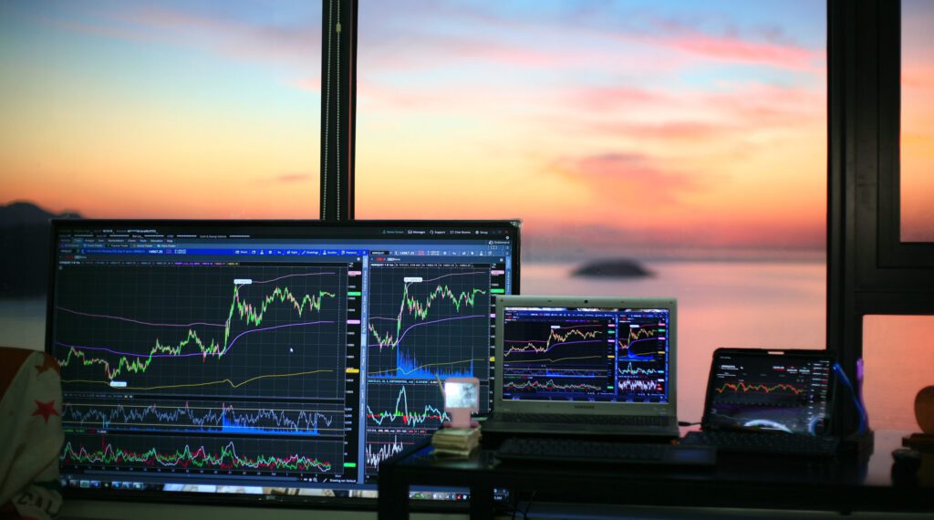Zahlreiche Bildschirme mit Börsencharts an einem Fenster