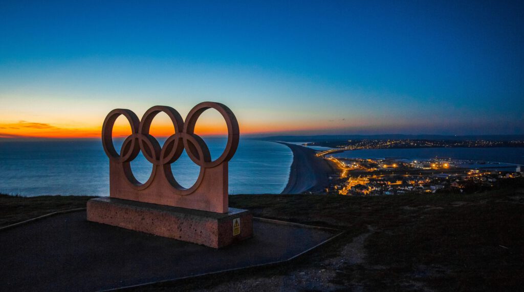 Olympische Ringe auf einem Hügel am Meer