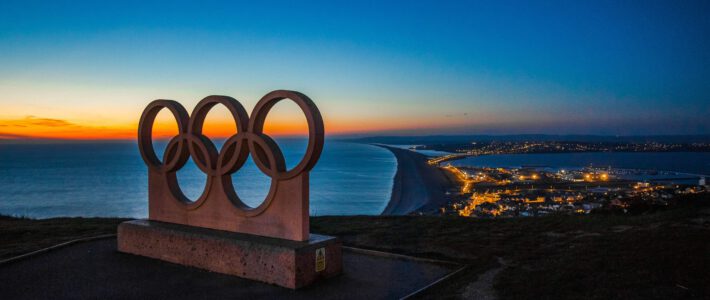 Olympische Ringe auf einem Hügel am Meer