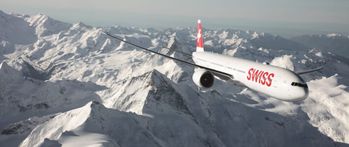 Ein Flugzeug der Swiss über schneebedecktem Gebirge