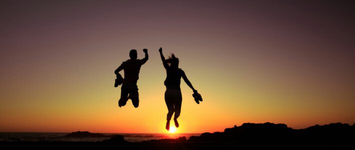 Zwei Personen springen vor Freude in die Höhe