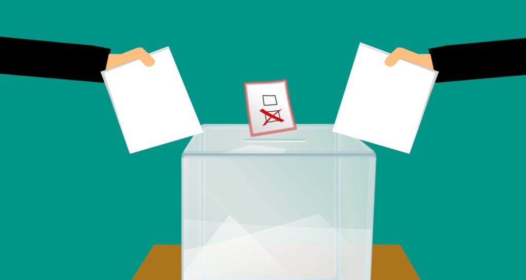 Eine Wahlurne mit Abstimmzetteln