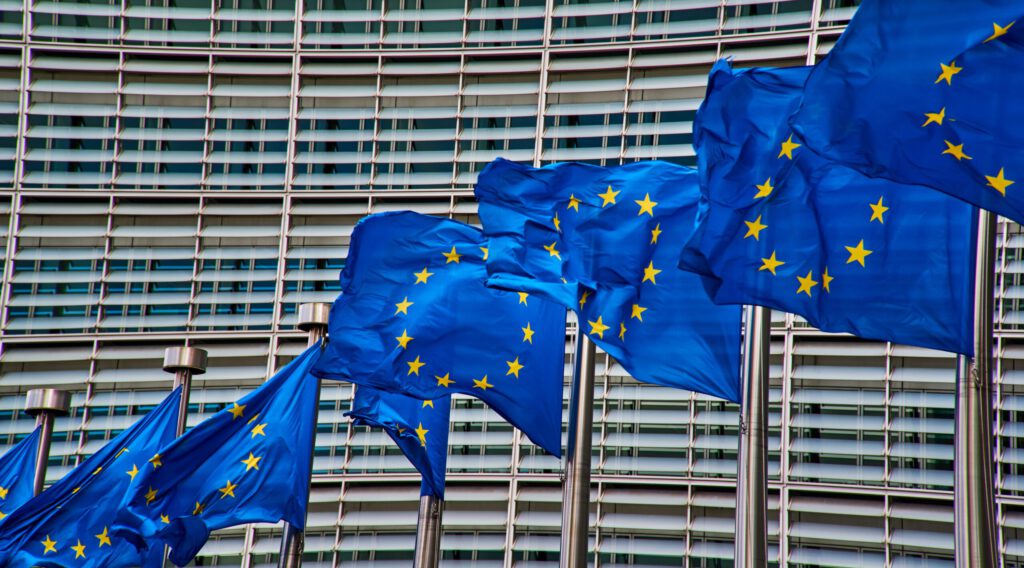 EU-Flaggen im Wind vor einem Gebäude in Brüssel