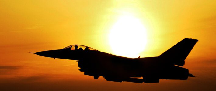 Ein Militärflugzeug in der Luft beim Sonnenaufgang
