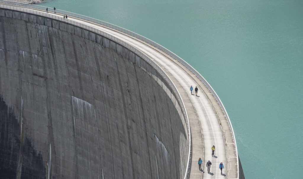 Ein Wasserdamm mit Menschen auf der Staumauer