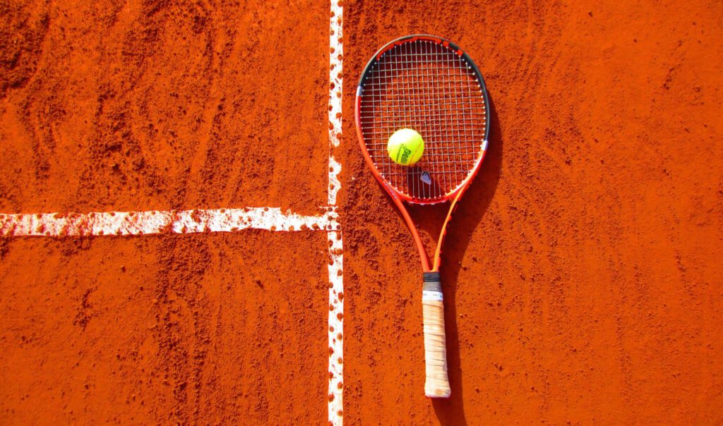 Ein Tennisschläger und Tennisball auf einem Spielfeld