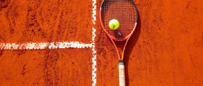 Ein Tennisschläger und Tennisball auf einem Spielfeld