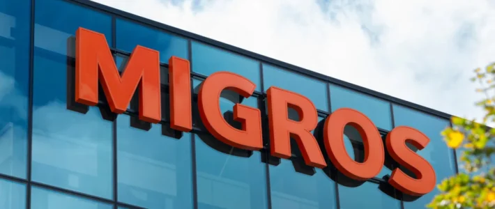 Das Logo von Migros an einem Supermarkt