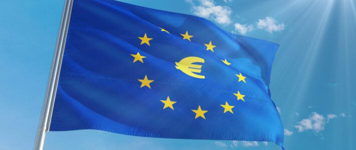 Eine EU-Flagge im Wind mit einem Euro-Symbol