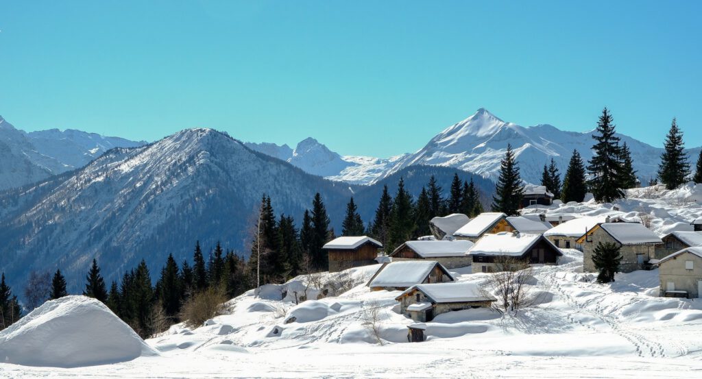 Schnee in den Alpen und Häuser im Schnee