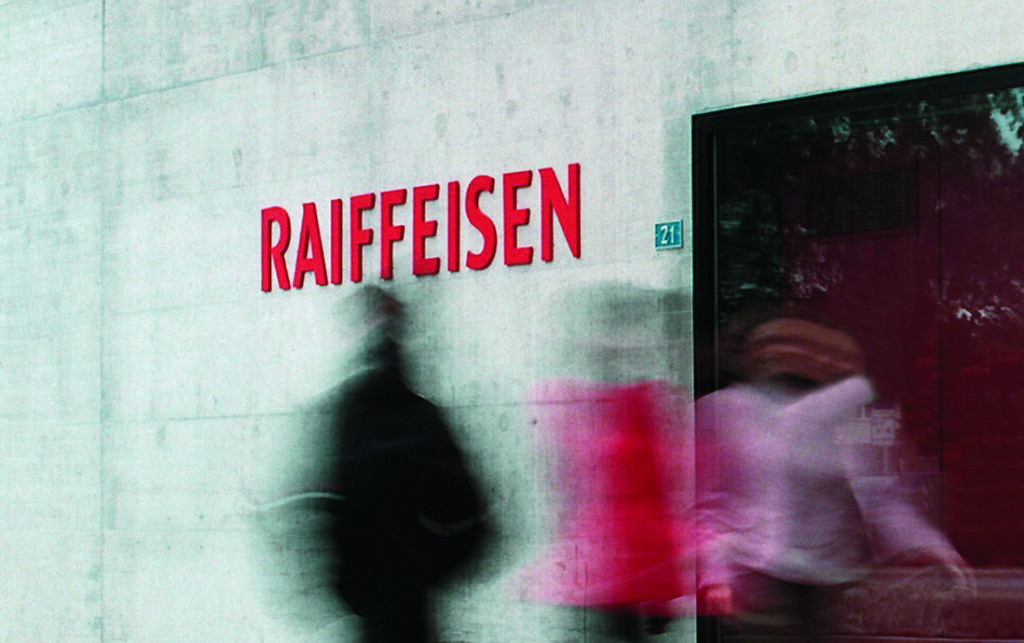 Raiffeisen-Logo und Personen vor einer Filiale