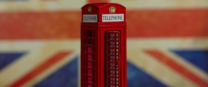 Eine britische Flagge hinter einer typischen Telefonbox aus Grossbritannien