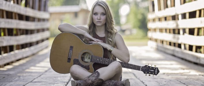 Eine Frau mit einer Gitarre auf einer Brücke