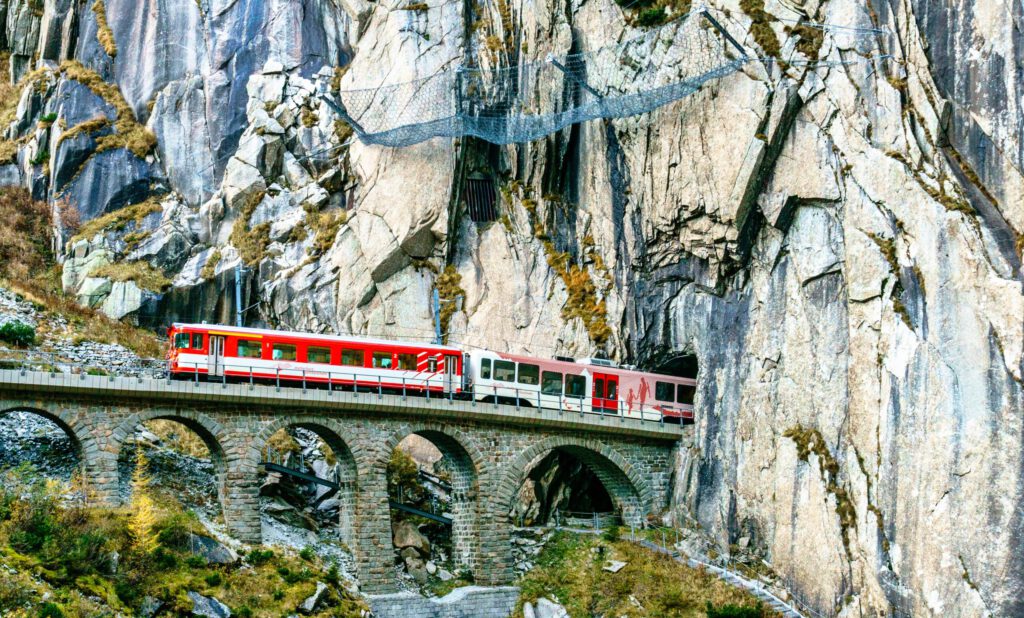 Ein Zug fährt in einen Tunnel in den Schweizer Bergen