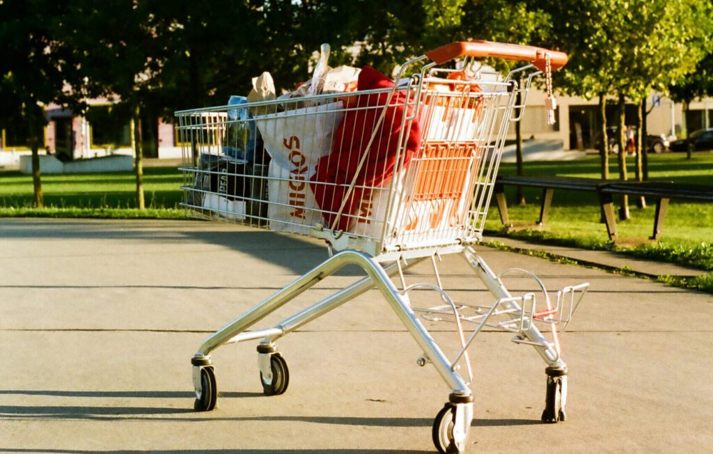 Ein Einkaufswagen mit Migros-Tüten auf einer Strasse