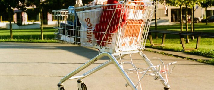 Ein Einkaufswagen mit Migros-Tüten auf einer Strasse