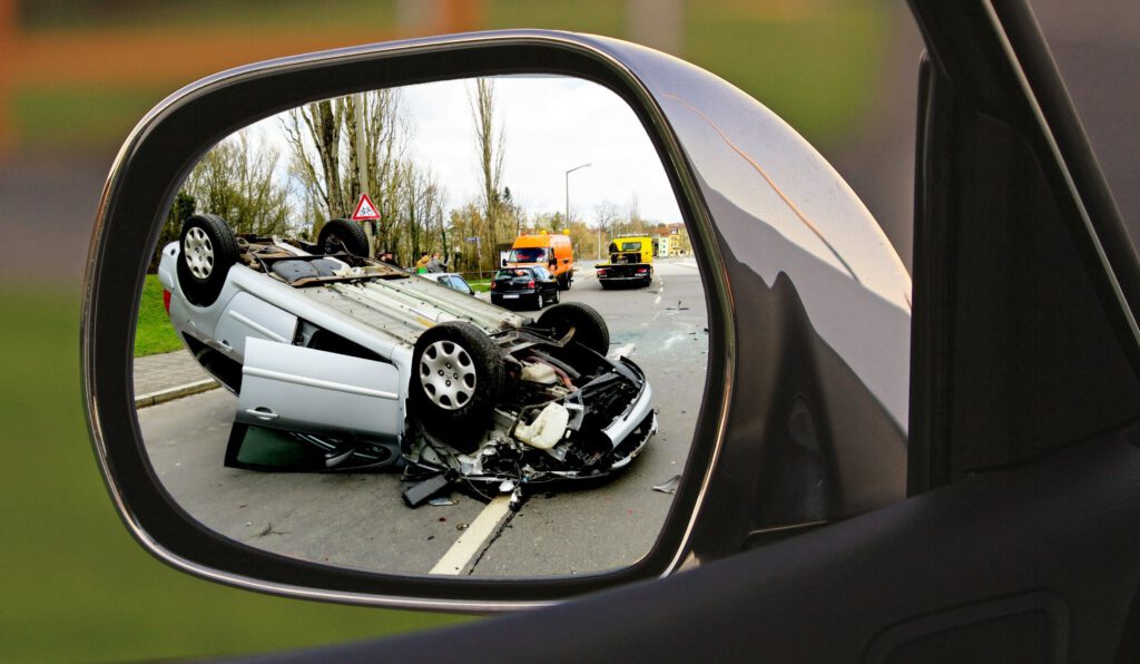 Ein Verkehrsunfall mit einem Auto auf dem Dach in einem Rückspiegel