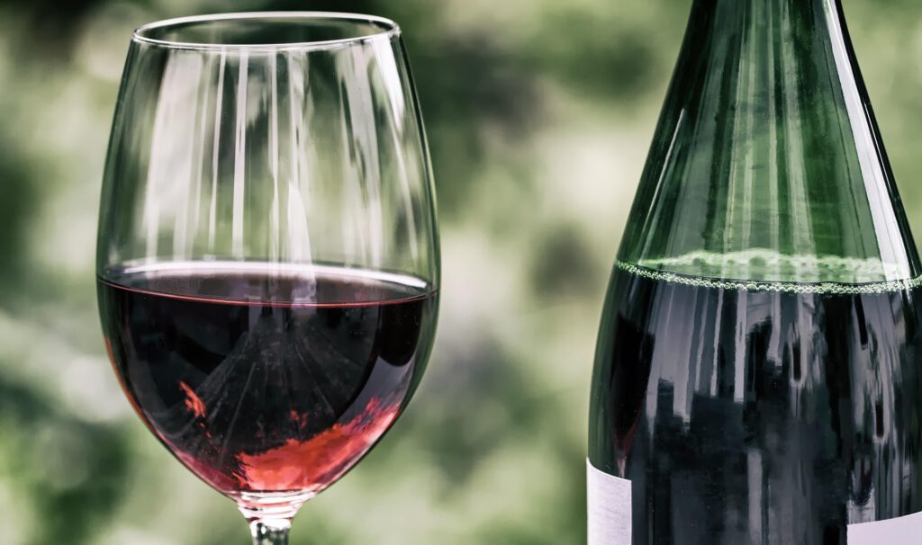 Ein Glas mit Rotwein und eine Weinflasche