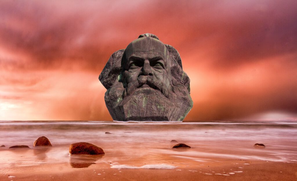 Ein Kopf von Karl Marx im Meer mit rotem Himmel