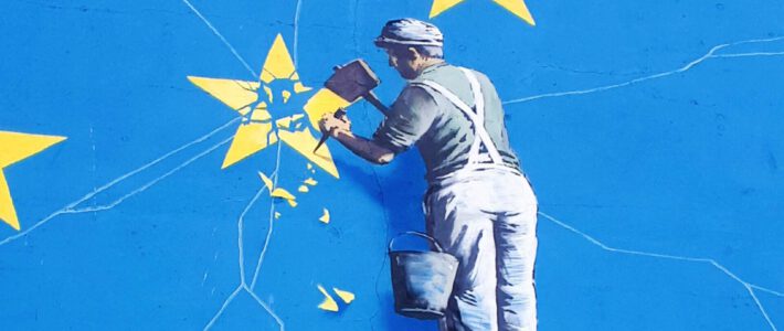 Ein Mann auf einer Leiter meisselt an einem EU-Stern
