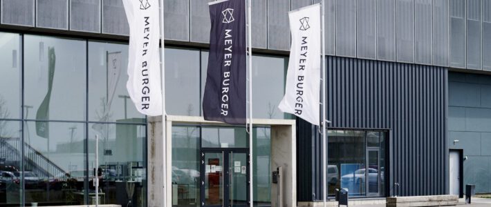 Flaggen von Meyer Burger vor einem Werk