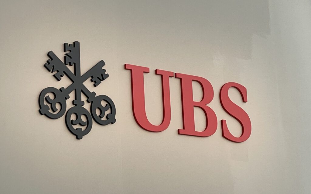 Logo der UBS an einer Wand der Messe Basel während der Art Basel 2025