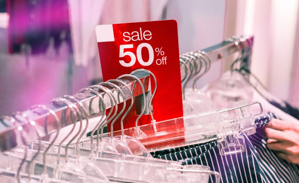 Ein 50-Prozent-Sale-Schild an einem Kleiderständer