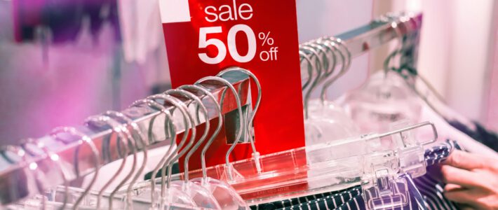 Ein 50-Prozent-Sale-Schild an einem Kleiderständer