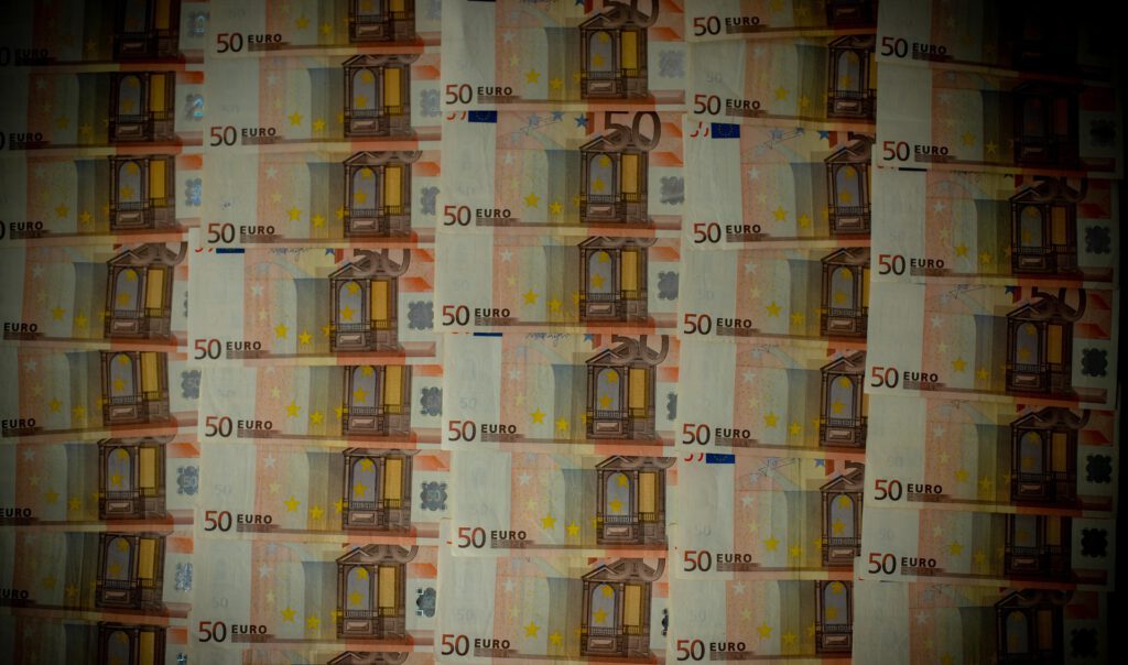 viele 50-Euro-Geldscheine in dunklem Licht