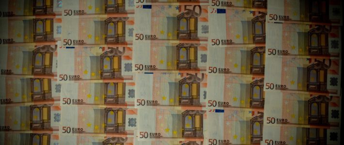 viele 50-Euro-Geldscheine in dunklem Licht