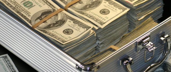 Dollar-Noten in einem Koffer und darum