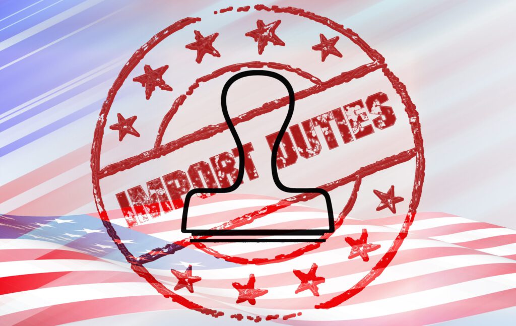 Ein Stempel und eine US-Flagge vor Import Duties