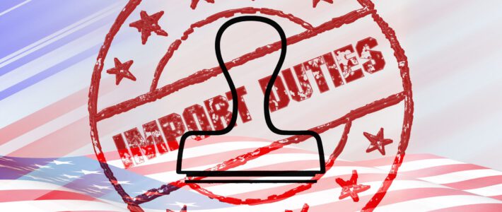 Ein Stempel und eine US-Flagge vor Import Duties