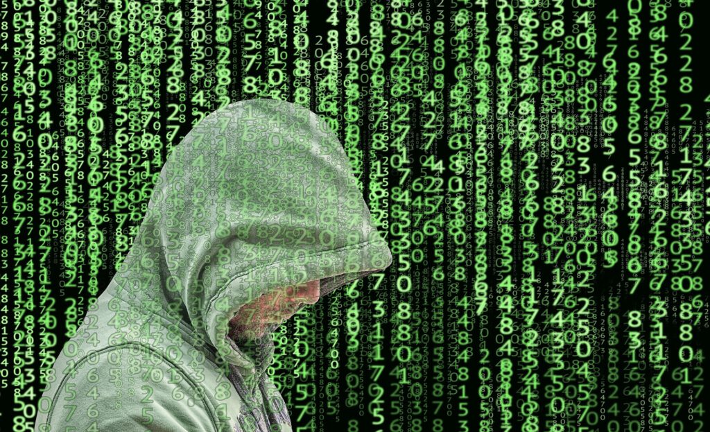 Ein Cyberkrimineller mit Kapuze vor Zahlencode