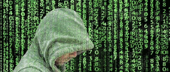 Ein Cyberkrimineller mit Kapuze vor Zahlencode
