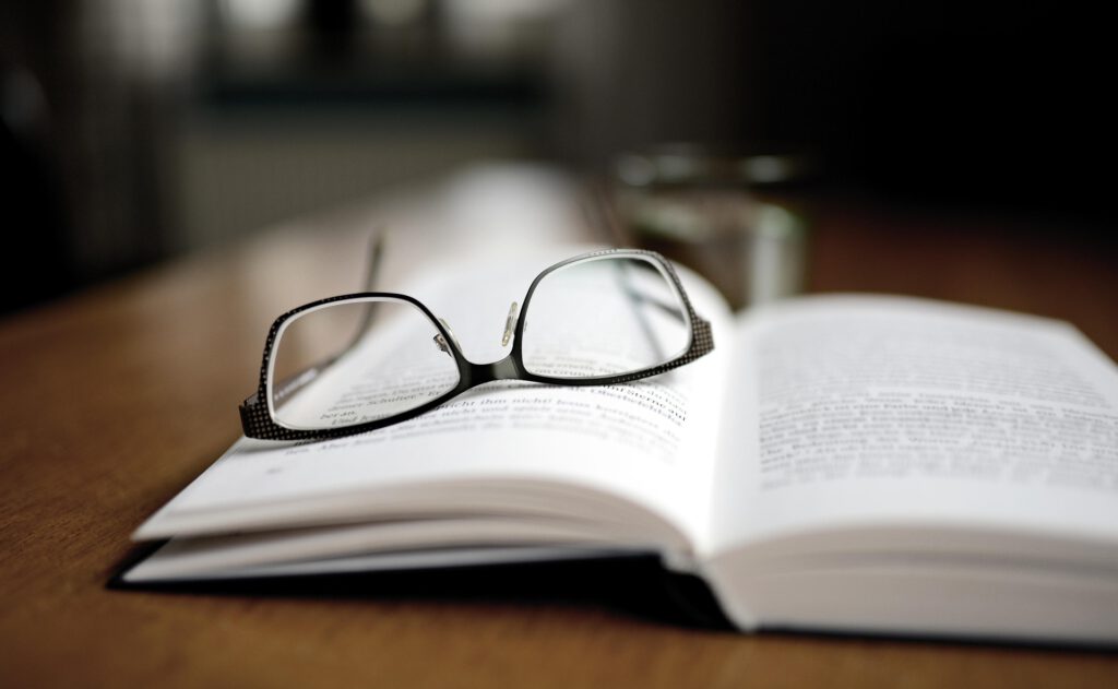 Ein aufgeschlagenes Buch mit einer Brille
