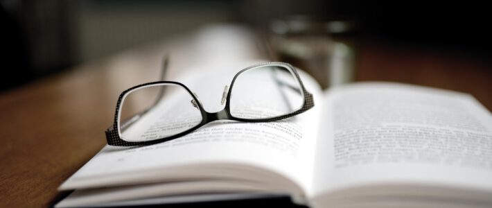 Ein aufgeschlagenes Buch mit einer Brille