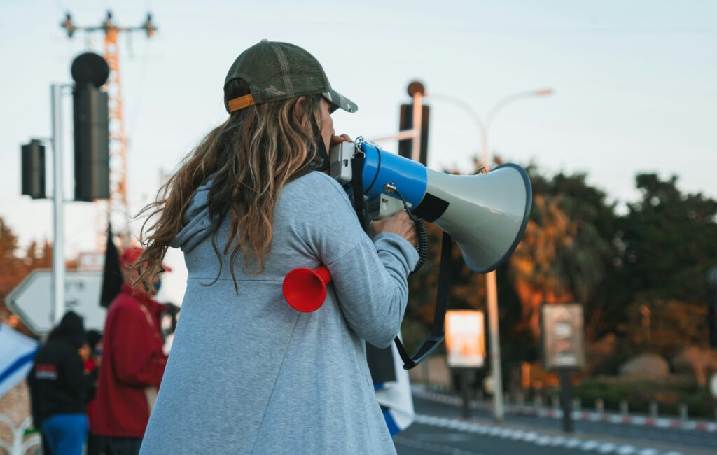 Eine Frau mit einem Megaphone an einer Kundgebung