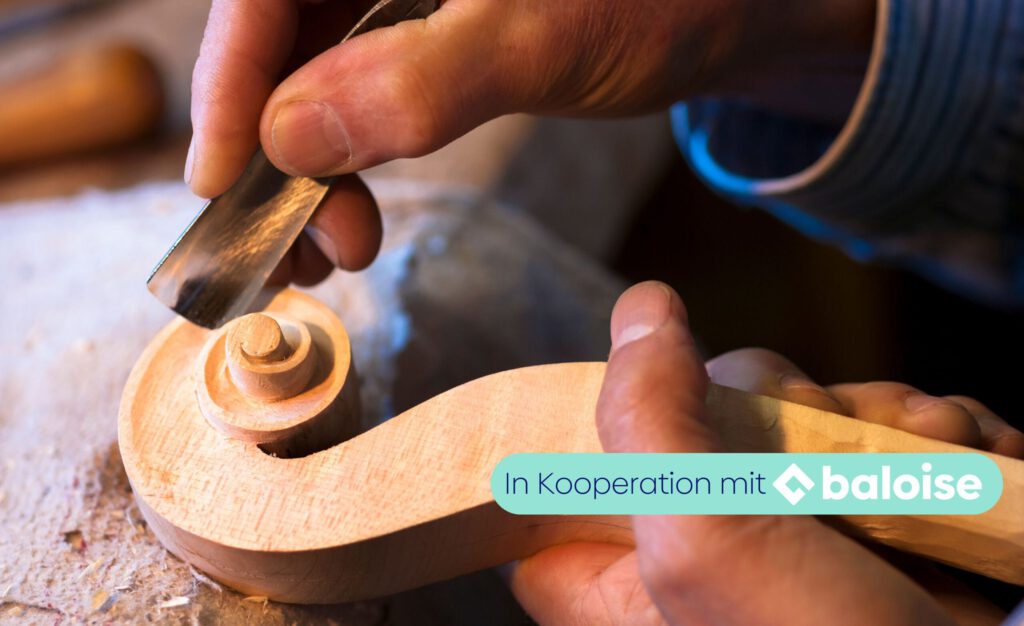 Hände bearbeiten ein Holzstück mit einem Werkzeug