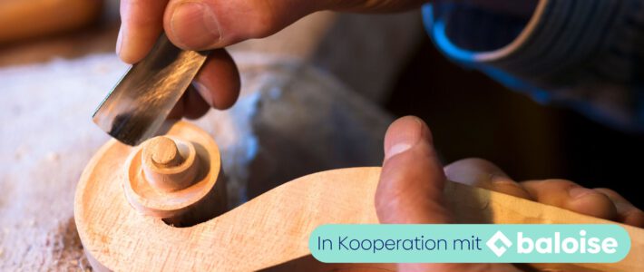 Hände bearbeiten ein Holzstück mit einem Werkzeug