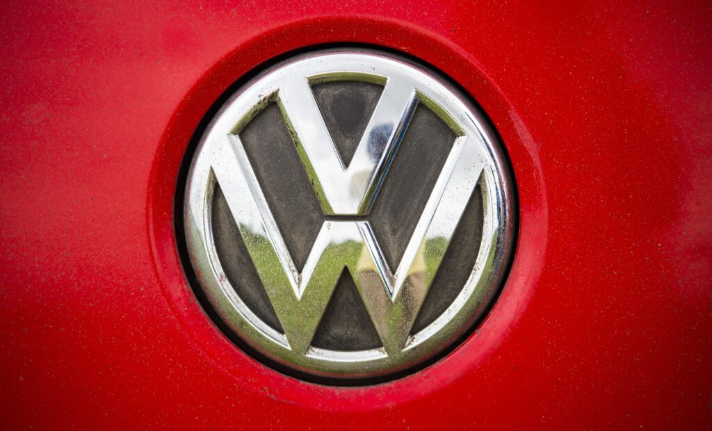 Logo von VW vor rotem Hintergrund