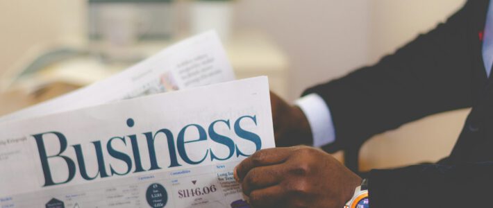 Schwache Wirtschaftsmedien belasten die Volkswirtschaft Ein Mann mit einer Luxusuhr liest den Wirtschaftsteil einer Zeitung