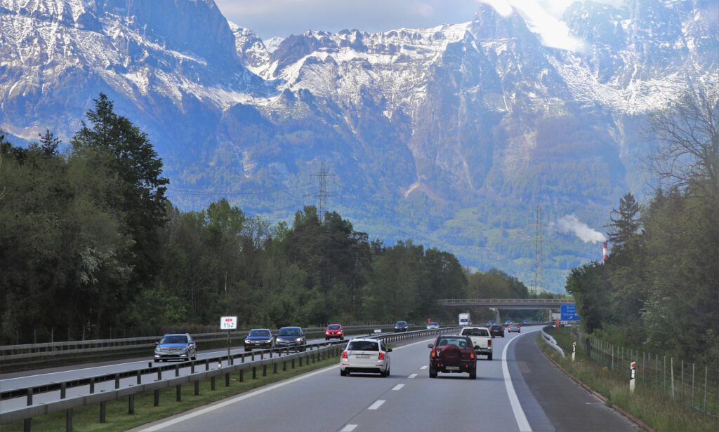 Eine Strasse mit Autos umgeben von Bergen