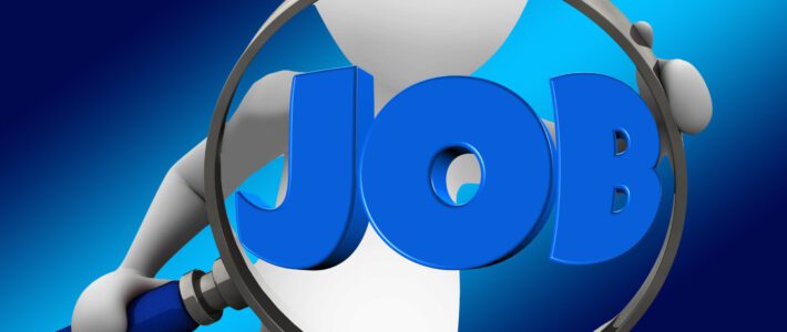 Eine schematische Person hält eine Lupe mit dem Wort JOB